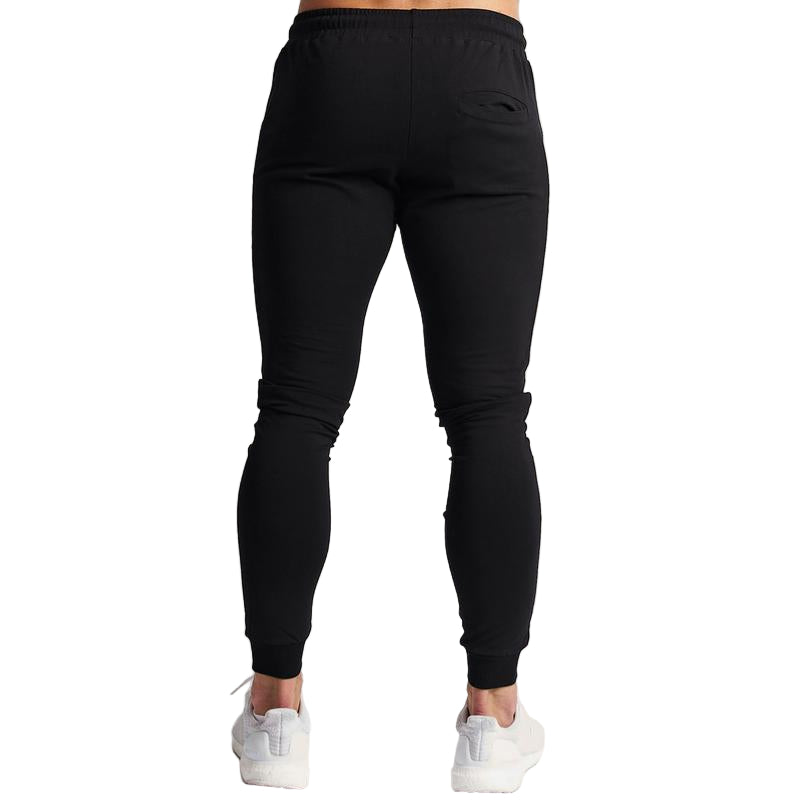 Black jogger pants worn by a person on a white background