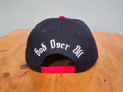 Black cap with 'God Over All' text on a wooden surface
