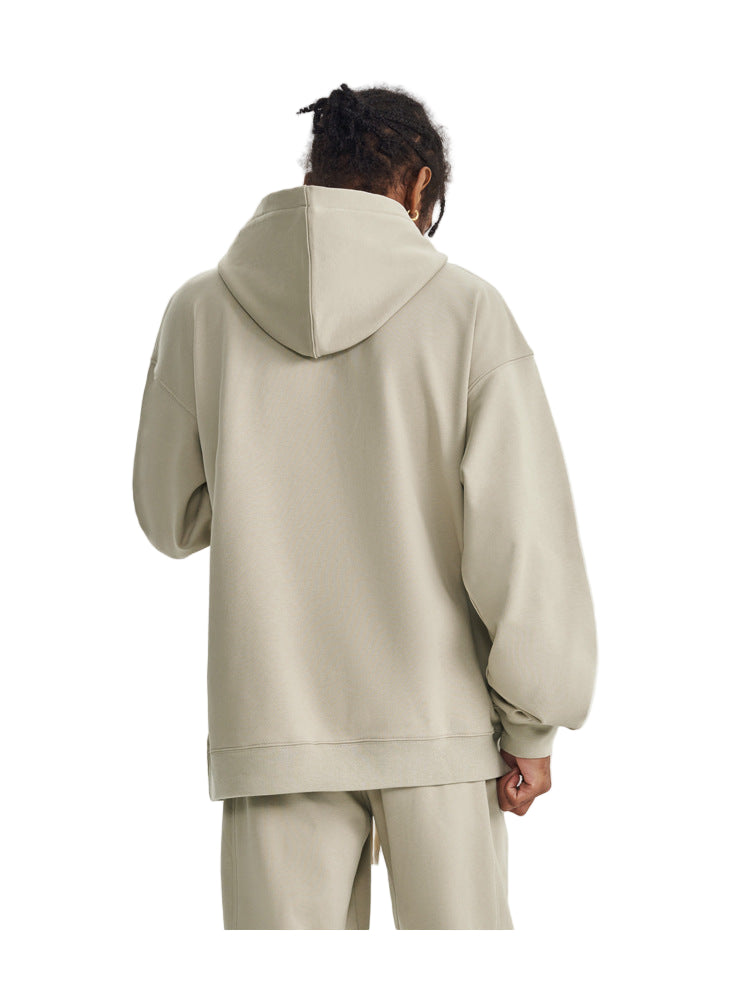 Person wearing a beige hoodie and pants on a white background