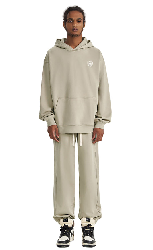 Person wearing a beige tracksuit with a logo on a white background