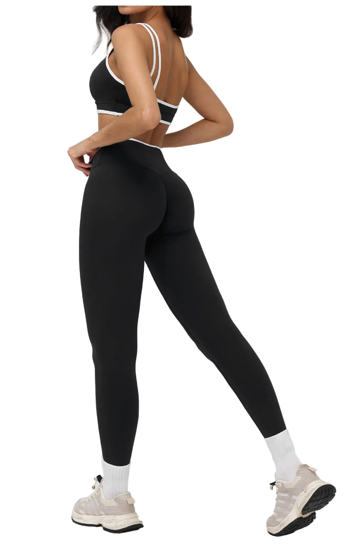 Person wearing black athletic leggings and sports bra on a white background