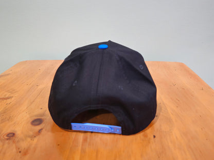 Black cap with a blue patch on a wooden surface