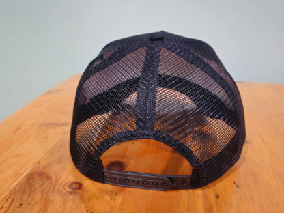 Black mesh cap on a wooden surface with a light gray background