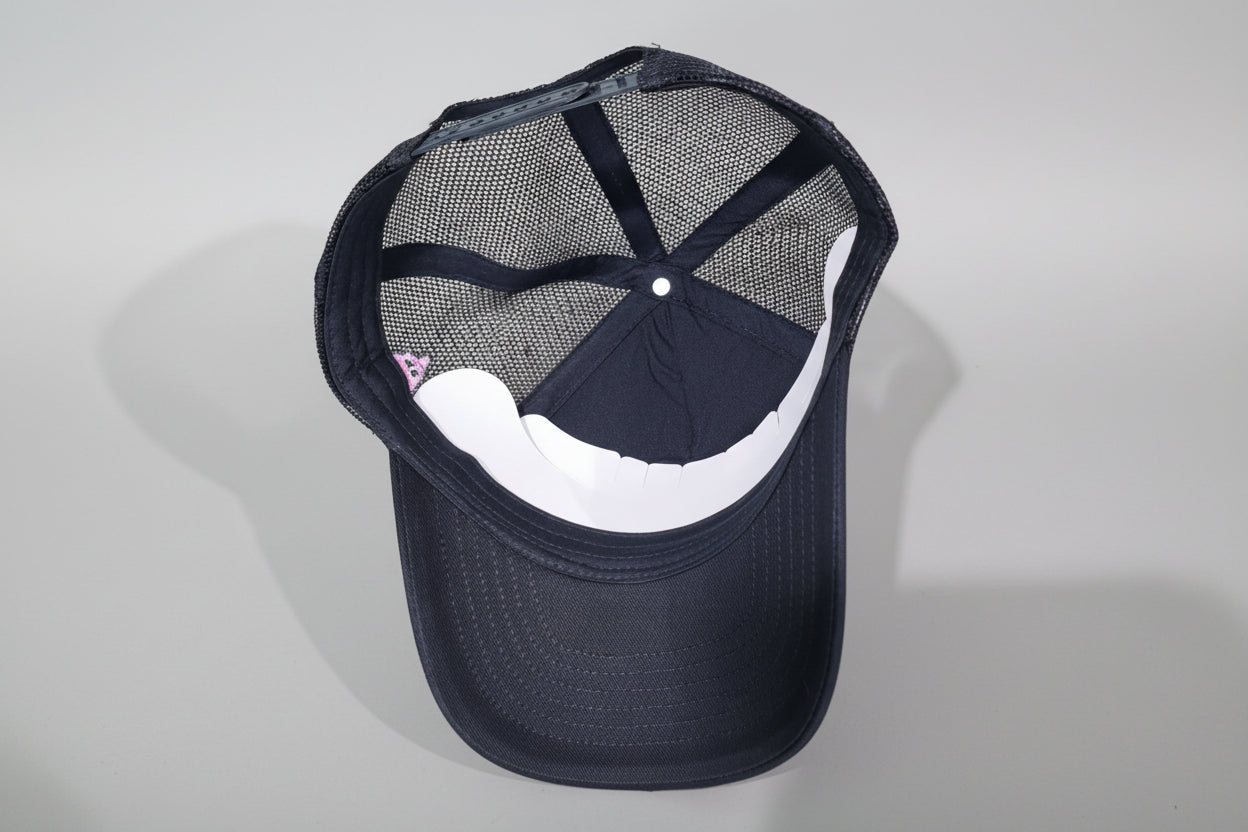 Black cap with mesh back on a wooden surface