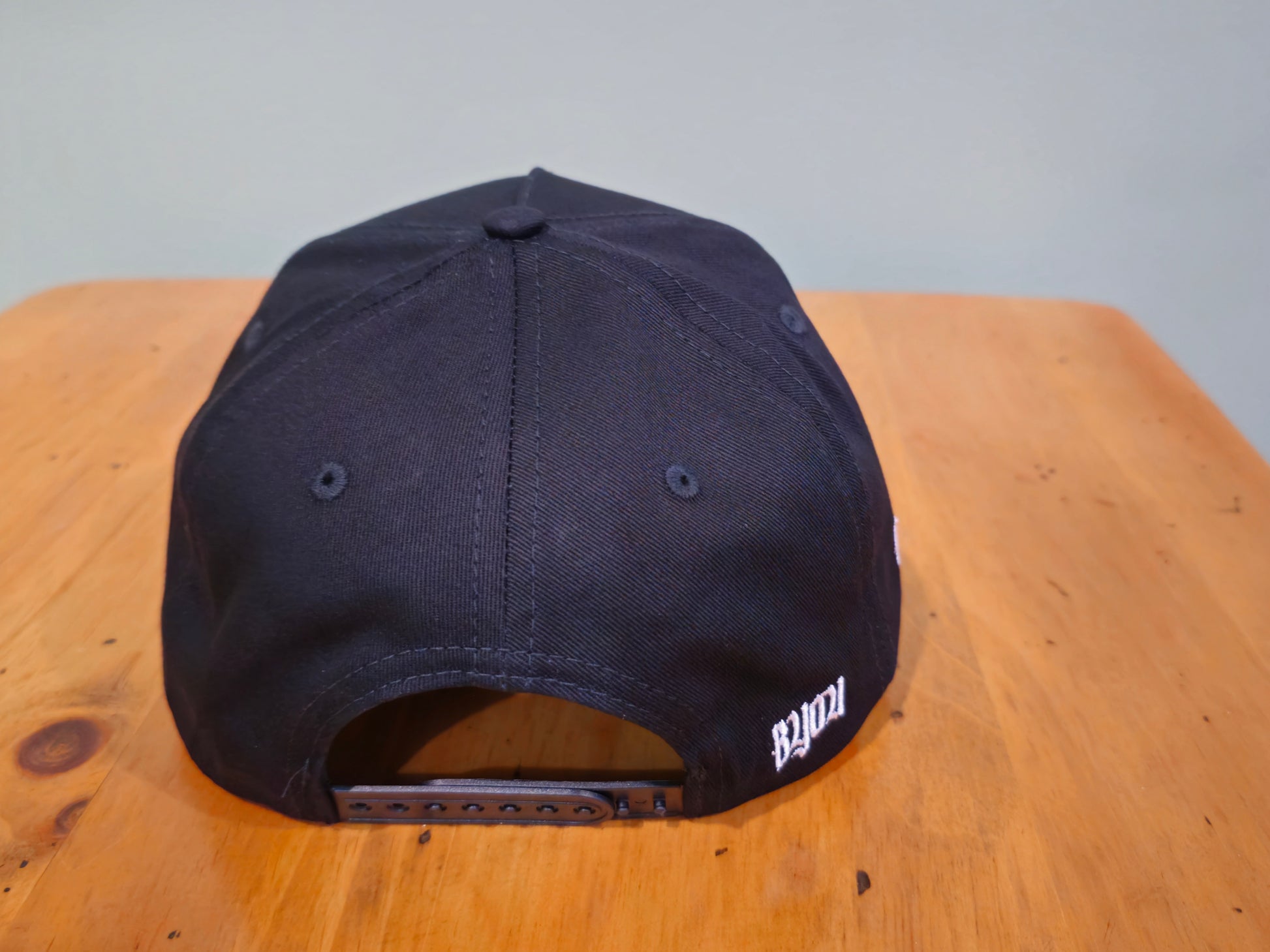 Black cap on a wooden surface with a plain background