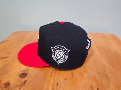 Black and red cap with a logo on a wooden surface