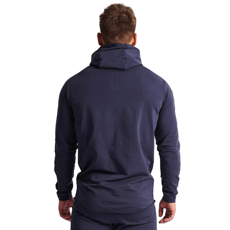 Man wearing a navy blue hoodie from behind on a light gray background