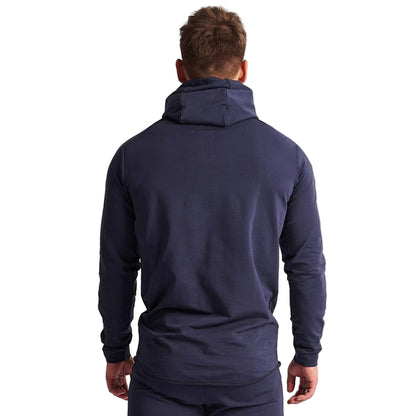 Man wearing a navy blue hoodie from behind on a light gray background