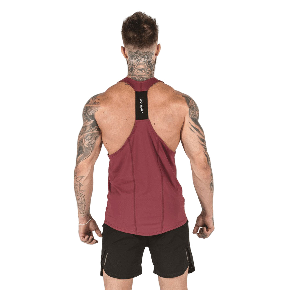 Man wearing a maroon tank top with a brand logo on the back, standing against a white background.