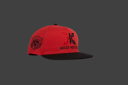 Red and black cap with branding on a gray background