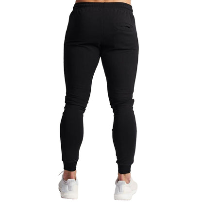 Black jogger pants worn by a person on a white background