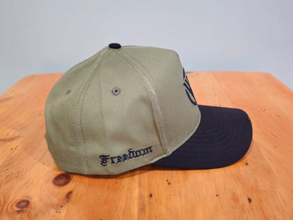 Two baseball caps, one beige and one black, on a wooden surface with a light gray background.