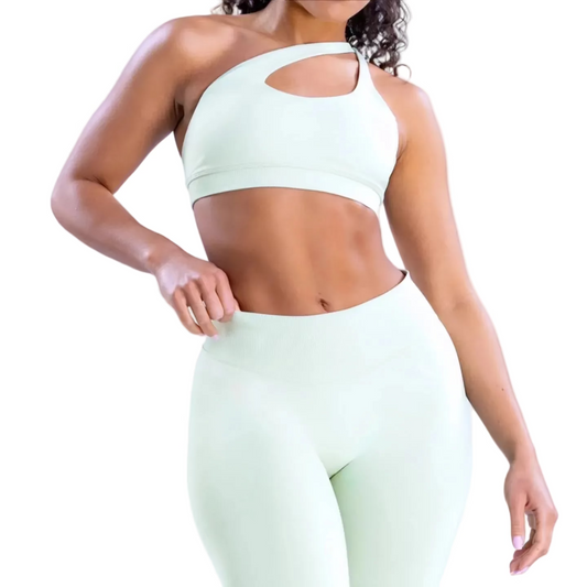Person wearing a light green sports bra and leggings set on a white background