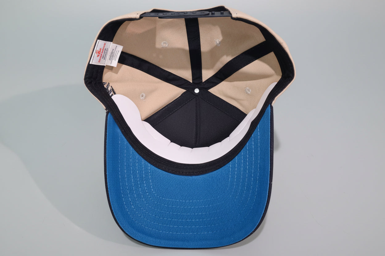 Blue cap with a black and beige interior on a wooden surface