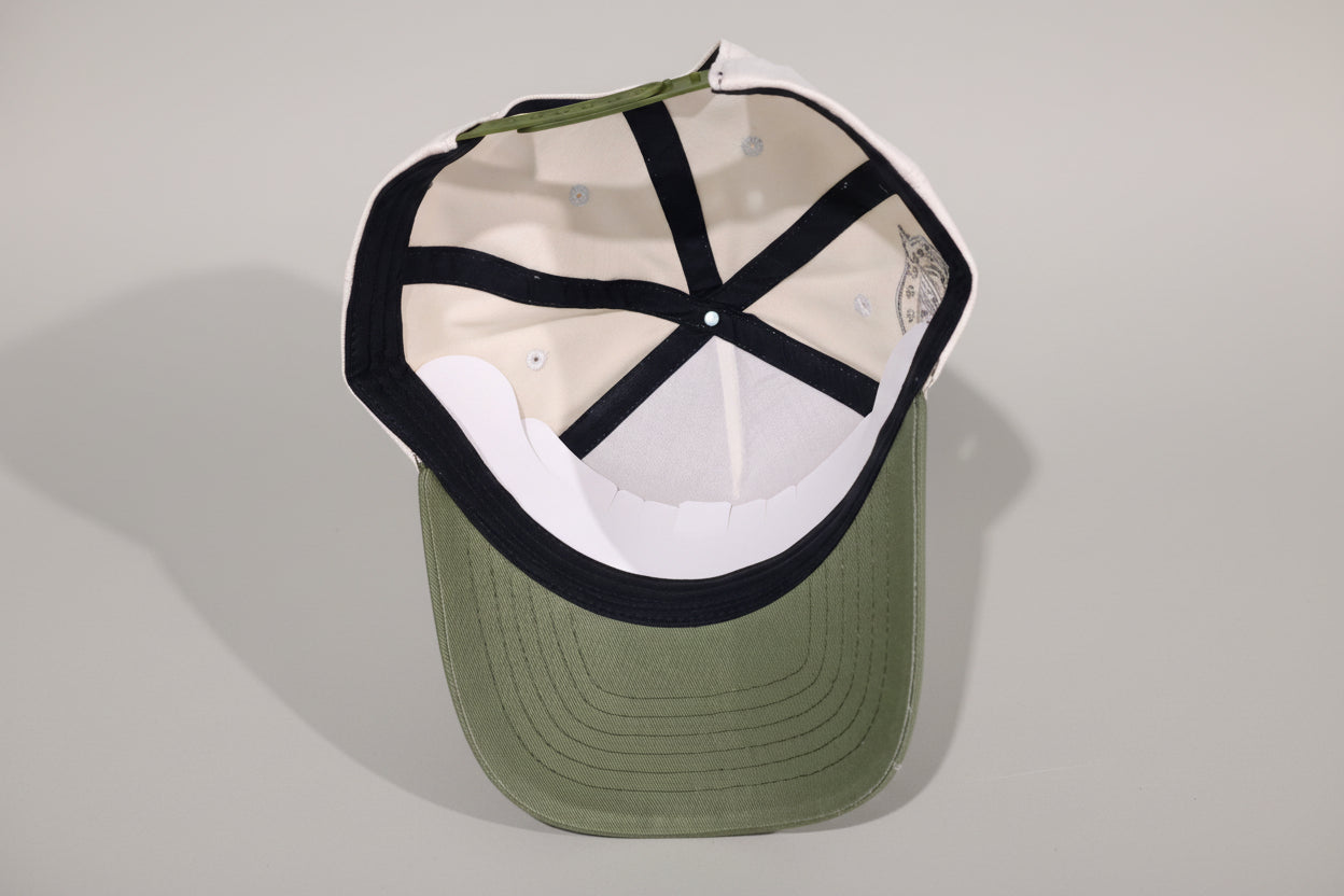 Green baseball cap with black and white interior on a wooden surface