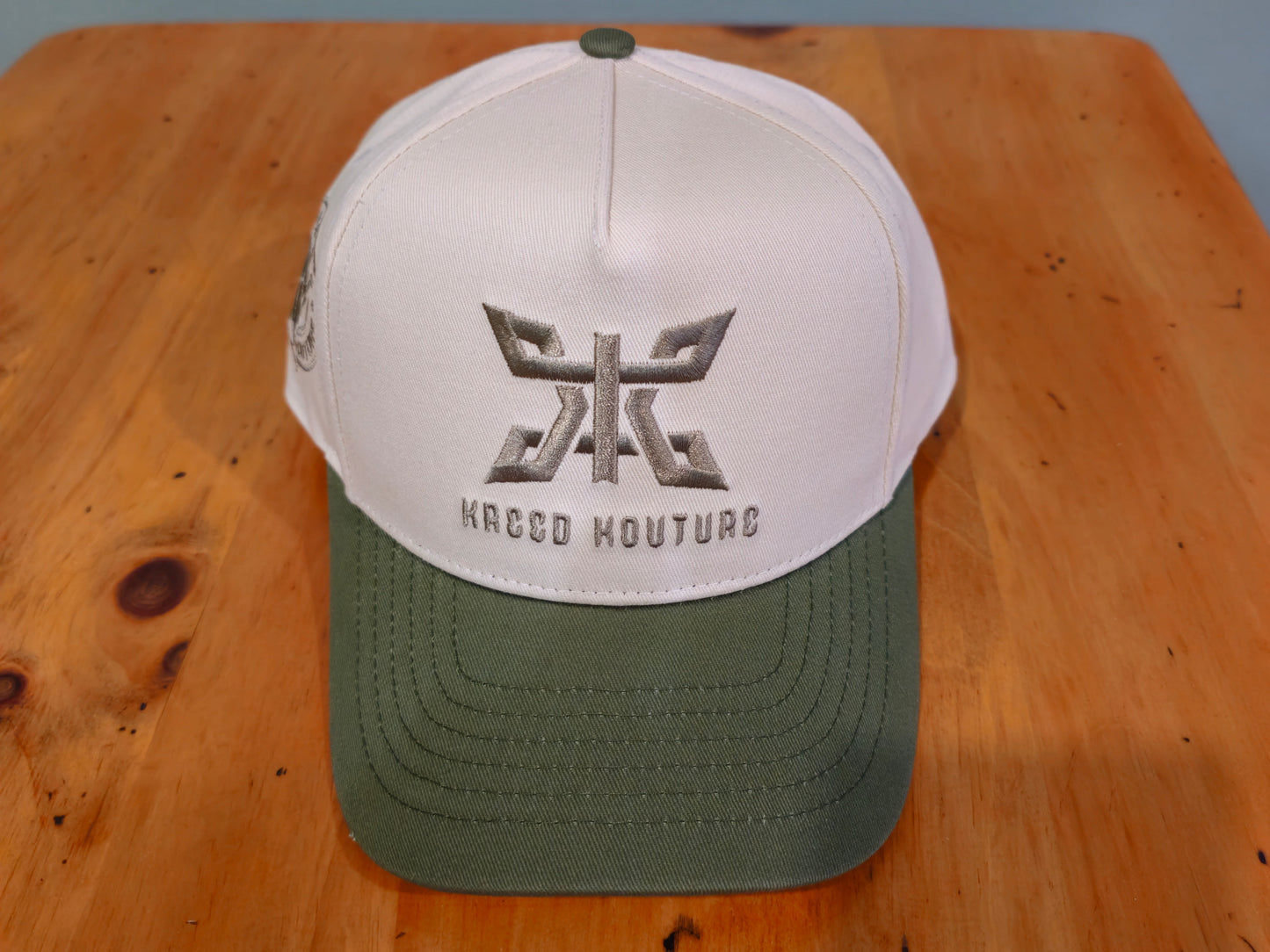 White and green cap with a logo and text on a wooden surface