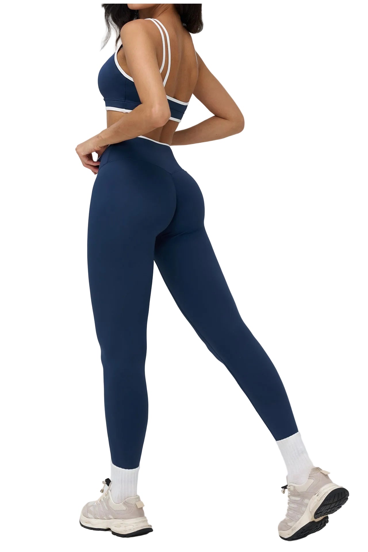 Person wearing navy blue leggings and sports bra on a white background