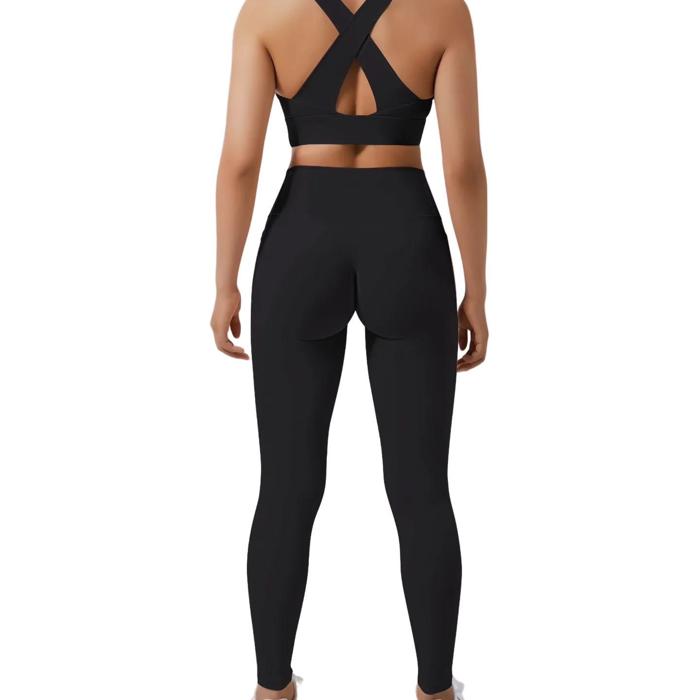 Person wearing black athletic leggings and sports bra on a light gray background