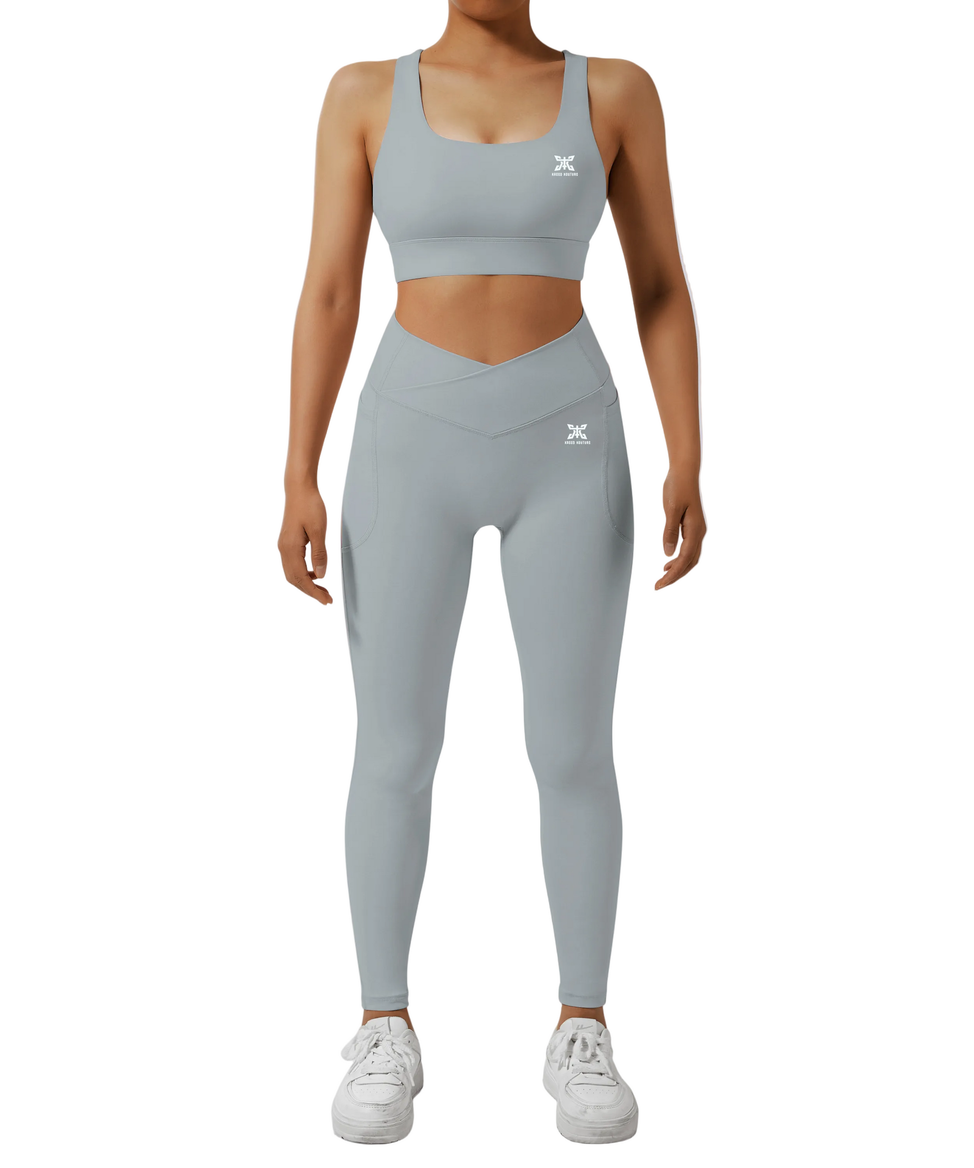 Person wearing a gray sports bra and leggings set on a white background