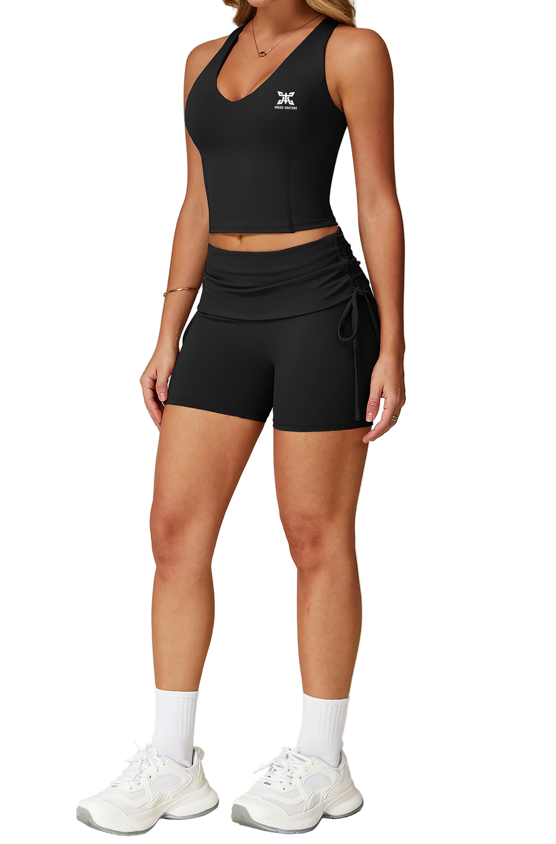 Person wearing a black athletic outfit with a logo on a light gray background