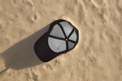 Black cap with mesh back on a white surface