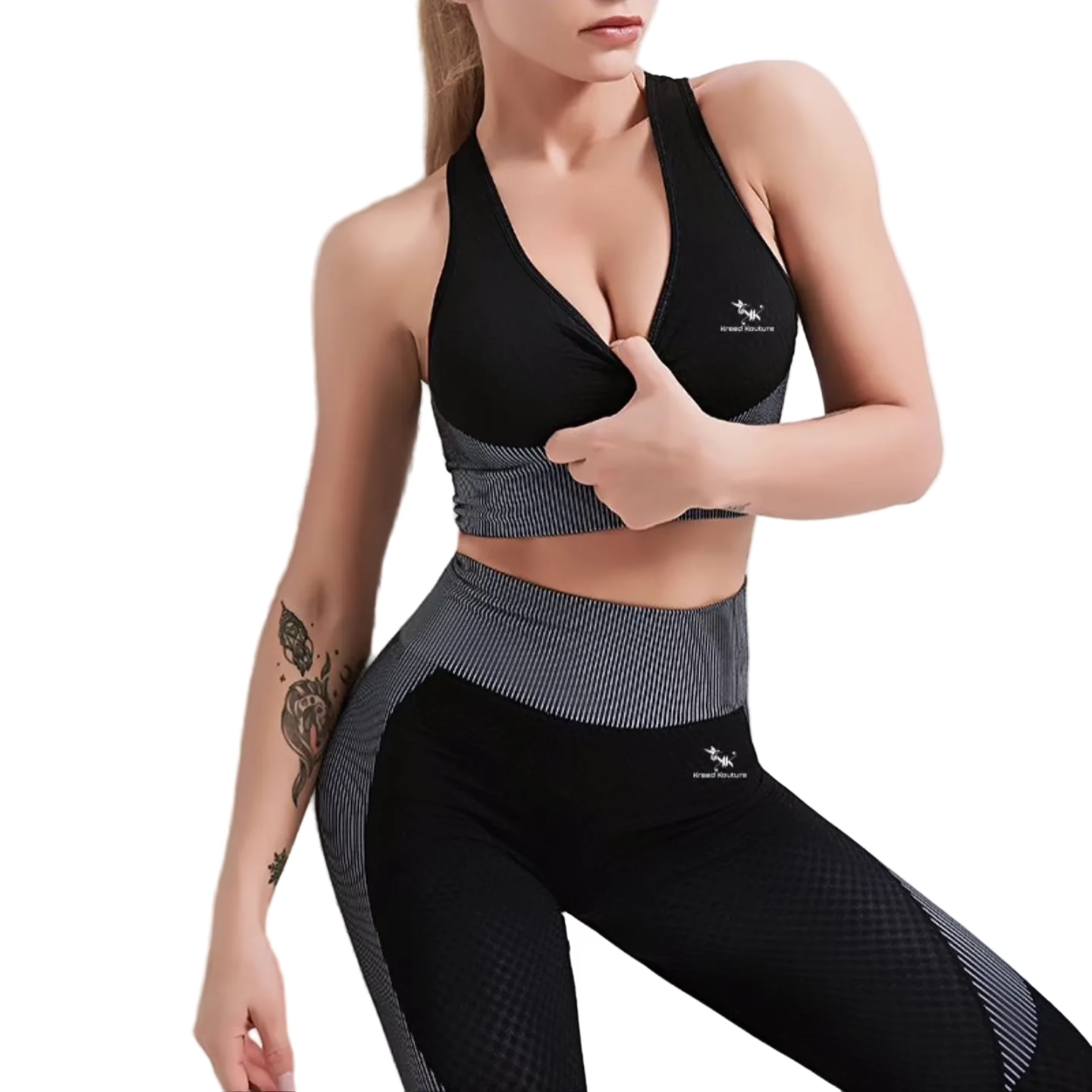 Woman wearing a black sports bra and leggings with a visible brand logo on a light background