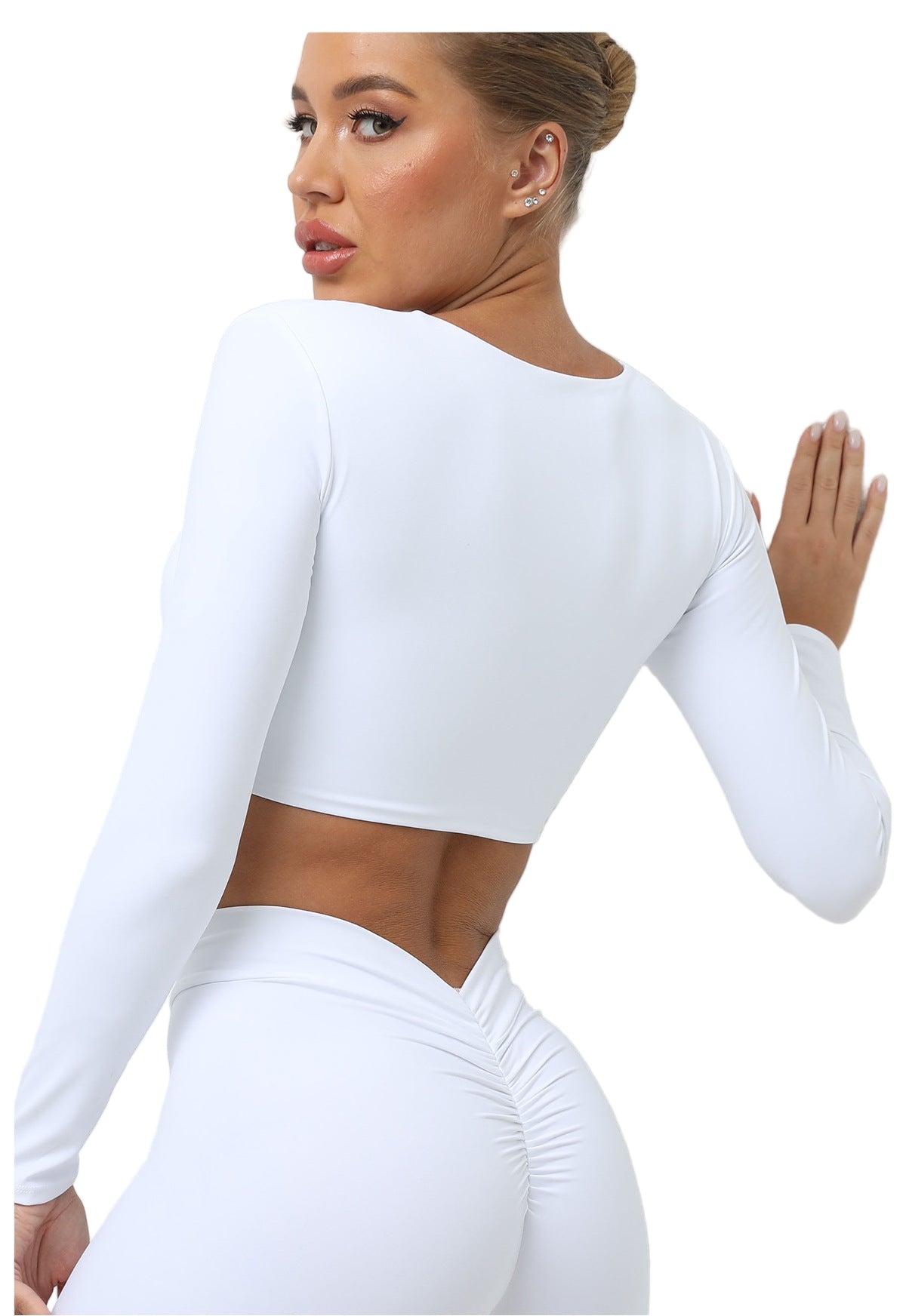 Woman wearing a white long-sleeve crop top against a light background