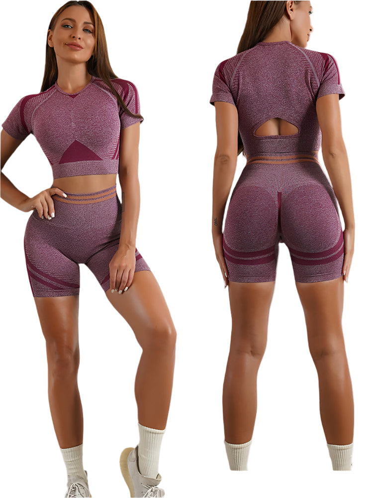 Woman wearing a maroon athletic outfit with cut-out design on a plain background